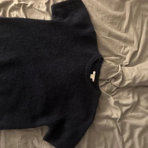 stickad tröja från Gina Tricot - Mysig svart stickad tröja från Gina Tricot med korta ärmar och rund halsringning. Perfekt för lager-på-lager och funkar lika bra till jeans som kjol. Tröjan har en enkel och stilren look som passar till många outfits.                                                     Tröjan är näst in till oanvänd 🤍 