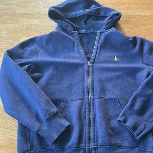Marinblå hoodie från Polo Ralph Lauren - Säljer nu min Ralph lauren hoodie. Storlek L men sitter som en M. Inga skador förutom på ryggen som du kan se på bilden. Hör av er vid frågor!