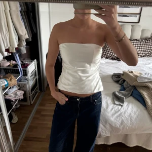 Vit satin bandeau tubtopp - Säljer en stilren vit bandeau tubtopp i glansigt satinmaterial. Från Zara 