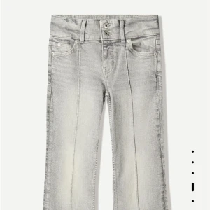 Grå bootcut jeans med pressveck - Snygga ljusgrå jeans med bootcut-modell och markerade pressveck framtill. Byxorna har hög midja med dubbla knappar och klassiska fem fickor. Tillverkade i stretchig bomullsdenim för en bekväm passform.