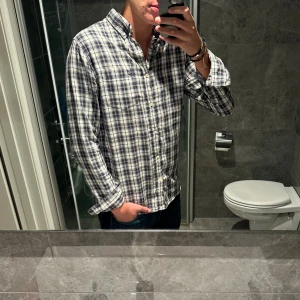 Rutig blåvit skjorta peak performance  - Riktigt snygg rutig skjorta från peak performance. Skjortan har en regular fit. Jag på bilden är 188cm och bär storlek M. Skjortan är i riktigt bra skick. Hör av er vid funderinga;)