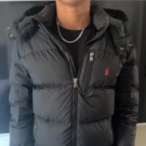 Ralph lauren jacka - Stilren ralph lauren jacka i storlek 14-16 motsvarar att den ungefär passar dig som är 160-170cm lång. Själv är jag 170 på bilden.  OBS: Ögglan man hänger jacka med är sönder och lappen innuti är lös men går att limma på. Jackan är köpt på kidsbrandstore.  