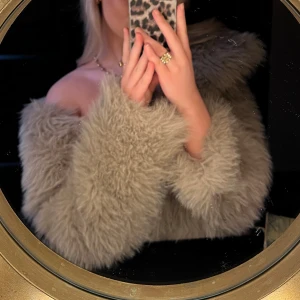 Beige fluffig pälsjacka - Säljer en supermjuk och fluffig beige pälsjacka med oversized passform. Jackan har lång ärm och är tillverkad i fuskpäls som ger en lyxig och trendig look. Perfekt för dig som vill sticka ut och hålla dig varm under kyliga dagar.