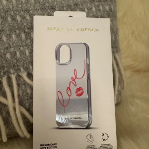 Ideal of Sweden Mirror Case Love Edition - Snygg spegelmobilskal från Ideal of Sweden, Love Edition. Design med röd 'love'-text och läppavtryck. Skal är droptestat och tillverkat av återvunna material. Passar iPhone-modeller, helt nytt i originalförpackning utan synligt slitage. Köpte denna och sedan insåg att det var till fel modell, missade oxå att lämna tillbaka den.