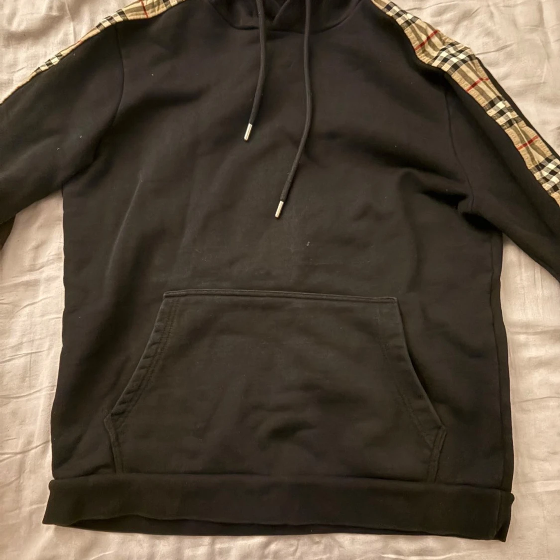 Svart hoodie med rutiga axelband