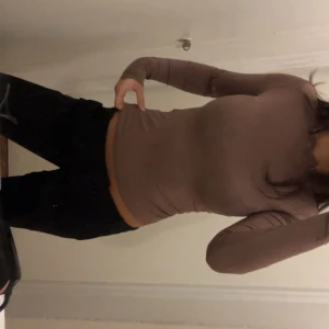 Brun topp med spets  - Säljer en helt ny brun långärmad topp från vero Moda med slim passform och snygg spetsdetalj vid halsen och slutet av ärmarna. Toppen är mjuk och stretchig, perfekt för dig som gillar en enkel men ändå stylish look. Passar dig som vill ha en basic topp med lite extra detalj. Aldrig använt, prislapp finns kvar köptes för 200. 