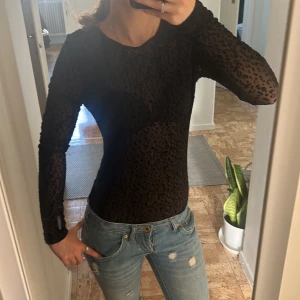 Svart body  - Säljer en svart långärmad bodysuit från Bik Bok med transparent mesh och leopardmönster. Säljer den pga att den aldrig kom till användning, skriv om ni har frågor☺️
