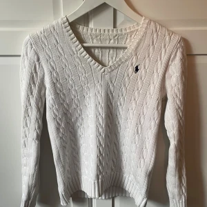 Kabelstickad Ralph Lauren - Super fin vit Raplh Lauren tröja som jag tyvärr måste sälja då jag växt ur den. Lappen ramlat av, i övrigt så är tröjan i bra skick och i ett fint material. Har dessvärre inga kvitton heller på att den är äkta då den var en present från ett syskon.