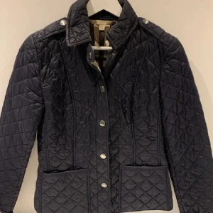 BURBERRY JACKA - Skriv privat för bilder! Burberry jacka dam passform, super fin som inte blivit använd på ett tag. Säljer för biligt pris då jag vill bli av med den fort då den tar oönskad plats. Pris kan diskuteras, storlek S men passar även XS perfekt. Marinblå påutsidan med den klassiska burberry mönstret på insidan.