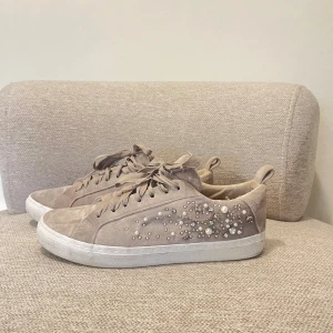 gråa skor - säljer dessa gråa sneakers fårn Zara med pärlor och stenar på( några av stenarna har åkt av) och ena skosnöret har defekter. säljer då dom inte passar mig🥰