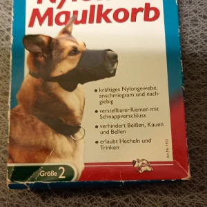 Trixie Nylon Maulkorb Größe 2 - Hundmunkorg i slitstarkt nylon, storlek 2. Justerbar rem med snabbspänne, tillåter hunden att flåsa och dricka. Förhindrar bitande, tuggande och skällande. Produkten är i gott begagnat skick, med mindre slitage på tyget.