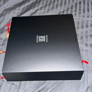 One Bold Chemist adventskalender - Upptäck 24 överraskningar med denna exklusiva adventskalender från One Bold Chemist. Varje röd påse innehåller en unik doftupplevelse – perfekt för dig som vill testa nya parfymer på ett roligt sätt.