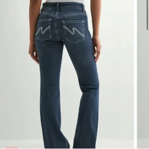 Blå bootcut jeans med broderade fickor - Snygga blå jeans från Nelly med bootcut passform och låg midja.