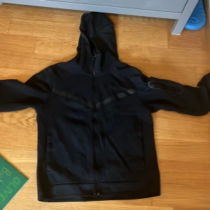 Svart Nike tech  - Svart  Nike tech i storlek M med hel dragkedja och huva.  Väldig bra sick , skulle säga passar både s och m knappt änvänd