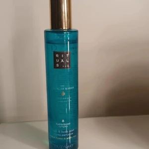 Rituals Karma Hair & Body Mist - Fräsch hair & body mist med lotusblomma och vitt te. Hydra-boost complex för extra fukt. 50 ml flaska, 90% naturligt ursprung. Perfekt för dig som vill ha en lätt och uppfriskande mist i vardagen. Tillverkad i Europa.