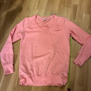 Ljusrosa sweatshirt från Gina Tricot - Mjuk och skön ljusrosa sweatshirt från Gina Tricot med rund hals och subtil V-detalj framtill. Tröjan har långa ärmar med muddar och är tillverkad i bomullsmaterial och polyester. Perfekt för dig som gillar enkel och clean stil. Lätt puff vid axlarna. 