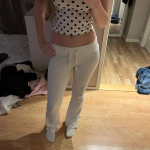 Vita mjukisbyxor från Nelly XXS - Säljer ett par vita mjukisbyxor från Nelly i storlek XXS. Byxorna har ribbad midja med snörning och är tillverkade i mjukt material. De har en rak passform med lätt utsvängda ben och sitter snyggt på kroppen. Perfekta för en chill och avslappnad stil.