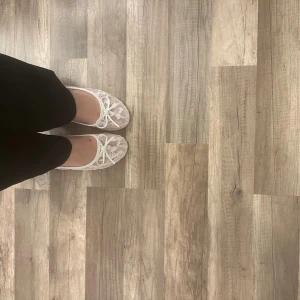 Vita spetsballerinaskor från Nelly - Säljer ett par vita ballerinaskor från Nelly med spets och blommigt mönster. Skorna har rund tå, platt sula och en söt rosett framtill. Perfekta för dig som gillar romantisk och feminin stil. Kommer i originalkartong.