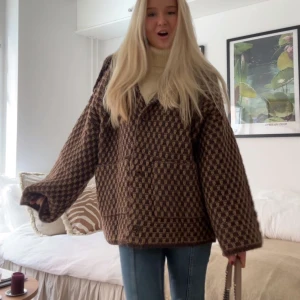 Slutsåld kappa Zara - Säljer en brun och beige rutig kappa från Zara med bred krage och knappar framtill. Jag har oftast storlek XS/S och den sitter super snyggt på mig även fast det är en L. Funkar att ha stickad tröja under. Slutsåld!! Använd 2 ggr