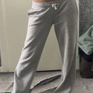 Grå mjukisbyxor med snörning - Superbekväma grå mjukisbyxor med snörning i midjan och avslappnad passform. Materialet är mjukt och stretchigt, och byxorna har en klassisk loose stil. Pris kan diskuteras