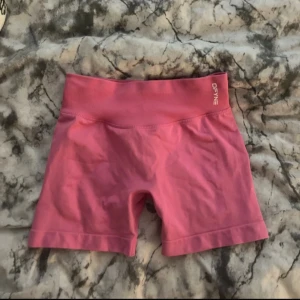 Rosa träningstights shorts från DFYNE - Säljer ett par rosa, tighta träningstights shorts från DFYNE. Har en seamless design som sitter skönt och formar kroppen. Perfekta för gymmet eller löprundan. Snygg och sportig look med elastisk midja. Storlek S, sann till storlek inga defekter. Modellen impact 