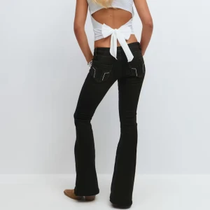 Svarta Lågmidjade bootcut jeans - Helt nya Snygga svarta Lågmidjade jeans med bootcut passform och coola bakfickor. Prislappen är kvar och dom är helt slutsålda på hemsidan.  Byxorna är från Gina Young 14+ i tall M, men dom passar bättre på en S. Innerbenslängden är ca 90cm. 