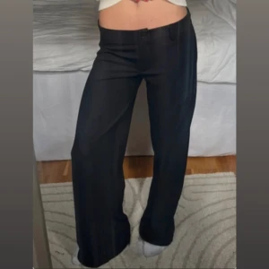 Svarta kostymbyxor från Nelly - Säljer ett par jättesnygga svarta kostymbyxor från Nelly i storlek S. Byxorna har låg midja, vida ben och klassisk kostymlook!💕