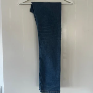 Levi's 512 blå jeans, slim taper - Säljer ett par klassiska Levi's 512 jeans i blå denim. Modellen har är i passformen ”slim taper” och har normal och justerbar midja. Med den ikoniska läderpatchen bak och snygga sömmar på bakfickan. Perfekt för dig som gillar tidlös stil och vill ha ett par jeans som funkar till allt.