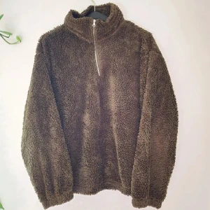 Grön-brun teddytröja - Supergosig, mjuk och fluffig teddytröja. Grön-brun, som skiftar lite beroende på vilket ljus man är i. Mått: Arm - 53 cm, Axelbredd - 48 cm, Längd - 58 cm. Återuppladdad för fri frakt. Jag har mycket annat uppe på sidan, både herr och damkläder. Köp gärna bundle för att få rabatt 🤗 