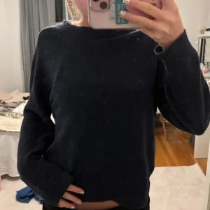 Mörkblå stickad tröja från Carin Wester - Mysig mörkblå stickad tröja från W. i storlek S. Tröjan har en klassisk rund halsringning och långa ärmar. Perfekt för lager-på-lager och chill dagar. Enkel och stilren design som funkar till det mesta.