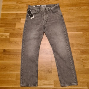Grå loose fit jeans Jack & Jones - I ny skick, sitter avslappnat och bekvämt.  Mått: Höft 50×2 cm | Midja 43×2 cm | Längd 98 cm | Innersöm 72 cm |Lårvidd 28×2 cm| Fotvidd 18×2 cm  Perfekt för dig som gillar en ledig passform och stilren look! Priset är förhandlingsbart. 
