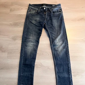 Replay jeans  - Säljer ett par snygga Replay jeans i mörkblå med klassiskdesign och knäppning fram. Jeansen har raka ben och diskreta slitningar för en cool look. Perfekta för dig som gillar stilrena och tidlösa jeans.