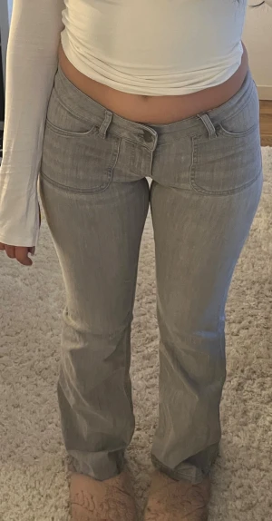 Low waist bootcut jeans från Nelly - Säljer mina ljusgrå bootcut jeans med låg midja från Nelly, storlek 36 men passar även lite större storlek eftersom det är så stretchiga och sköna