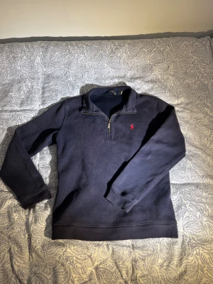 Ralph lauren half zip  - Snygg mörkblå half-zip i bra skick! Klassisk och stilren half-zip i mörkblått, perfekt som både vardagsplagg och layering-piece. Bekväm, mjuk och sitter riktigt snyggt. Passar året runt och funkar till allt — jeans, cargos eller shorts. Storlek: S Skick: Mycket bra, inga defekter.  Perfekt för dig som gillar tidlös stil och kvalitetsplagg!