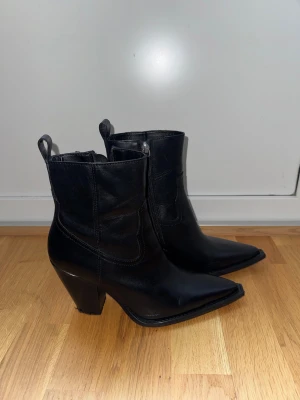 Svarta cowboy boots med klack - Snygga svarta cowboy boots med spetsig tå och rejäl klack. Boots i skinn med dragkedja på sidan och klassiska detaljer upptill. Perfekta för dig som vill ha en cool och edgy stil ❤️. De är i äkta skin köpta från mango 