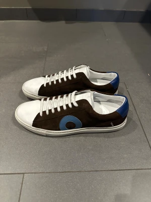 Oliver Cabell bruna och vita sneakers - Schyssta Olivers cabells, aldrig använda. Lite smuts på dem då de har legat på lager, inget som inte går bort. Storlek 43