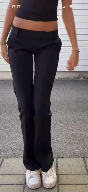 Svarta bootcut kostymbyxor - Snygga svarta kostymbyxor med bootcut-snitt och låg midja. Byxorna har klassisk passform och är perfekta för dig som gillar stilrena och tidlösa plagg. Materialet är mjukt och följsamt, vilket gör dem bekväma att bära hela dagen. Det finns en Norp på ena benet kom privart för bild på de🥰