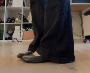 Svarta Vagabond ballerinaskor med kilklack - Säljer ett par svarta ballerinaskor från Vagabond i storlek 37. Skorna har rund tå, låg kilklack i trälook och är gjorda i skinn. Insidan har ett blommigt mönster och yttersulan har ett snyggt mönster. Perfekt för dig som gillar stilrena och bekväma skor.