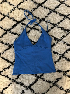 Blå linnetopp från Gina Tricot XS - Supersnygg blå linnetopp från Gina Tricot i storlek XS. Toppen har smala axelband och knyt i nacken, med en djup v-ringning framtill. Materialet är mjuk bomull och toppen har en clean, enkel look som är lätt att matcha med jeans eller kjol.🥰🫰🏻