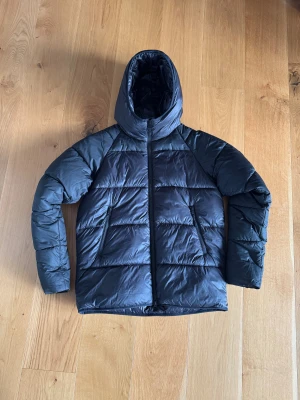 Svart Barbour International pufferjacka - Svart pufferjacka från Barbour International. Jackan är inköpt på NK för två år sedan för 3600 kr. Kvitt och lappar finns kvar. Jackan är i storlek S men är något större i storleken. Passar mig bra på 178 cm. Jacka är knappt använd och är i mycket fint skick. Tveka inte på att höra av dig vid funderingar!