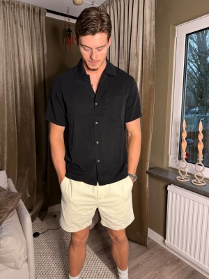 ARKET Svart kortärmad skjorta  - Säljer en kortärmad skjorta från ARKET! Väldigt stilren och passar till typ allt i din garderob.