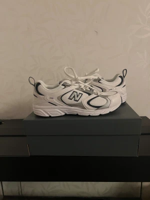 Vita New Balance 408 sneakers - Snygga vita New Balance 408 sneakers med svarta och grå detaljer. Dom är helt nya och säljer då jag inte använder dom. Nypris är 945kr. 