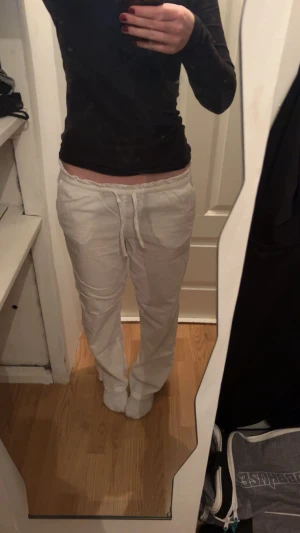 Vita linnebyxor med snörning - Säljer ett par vita linnebyxor som även passar storlek S med dragsko i midjan och raka ben. Byxorna har en avslappnad passform och är perfekta för en chill och luftig stil. Fickor framtill och mjukt, svalt material som känns skönt mot huden.