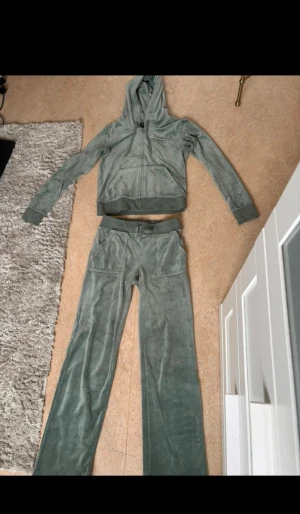 Juicy Couture gröna mjukisbyxor  - Tröjan är i storlek S.                                                            Byxorna är i storlek XS.                                                   Byxorna har lite brännhål på framsidan av låren och ena metall saken på snörena är borta.                  Se bild ( 2-3 ).  Resterande är felfritt