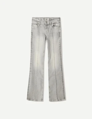 Grå bootcut jeans från Bershka - Säljer ett par grå bootcut jeans från Bershka med markerad pressveck längs benen och dubbla knappar i midjan. Jeansen har klassisk femficksdesign och är tillverkade i denim med lätt tvättad look. Perfekta för dig som gillar en retroinspirerad stil.- mörkare färg än på bilden!!!