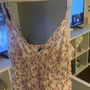 Blommigt sommarlinne Gina Tricot XS - Supersöt kort klänning från Gina Tricot i storlek XS. Klänningen är vit med små rosa blommor, har smala axelband och v-ringning. Perfekt för varma dagar och har en lätt, luftig känsla tack vare bomullsmaterialet. Nypris: 299