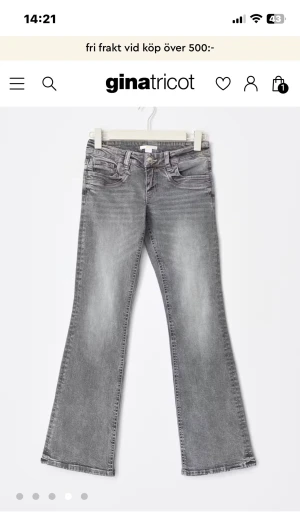 Grå low waist jeans från Gina Tricot - Snygga grå jeans med bootcut från Gina Tricot. Modellen har låg midja, klassiska fem fickor och bälteshällor. Jeansen är tillverkade i mjukt denimtyg med lätt tvättad look och dragkedja med knapp framtill. Perfekt för dig som gillar retrovibbar och avslappnad stil. 
