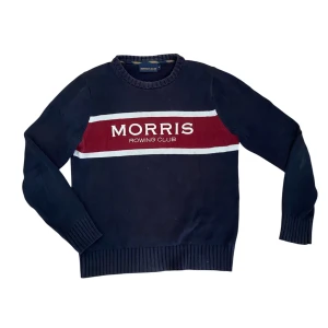 Morris tröja - Snygg marinblå stickad tröja från Morris Rowing Club med vit och vinröd rand över bröstet och tydlig logga. Rund hals och ribbade muddar vid ärmslut och nederkant. 