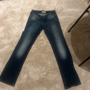 Blå Lee bootcut jeans  - Snygga blå jeans från Lee med bootcut passform och coola broderade bakfickor. Jeansen har klassisk knappgylf, slitningar och ljusare partier framtill och baktill för en schysst tvätt.  Det står ingen storlek i byxorna så om ni vill ha måtten kan ni skriva men de passar mig perfekt som är 160😇