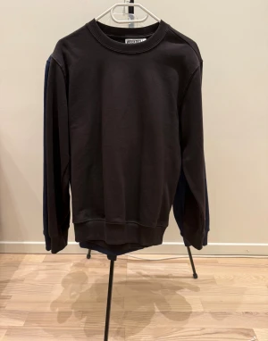 Brun sweatshirt  - En stilren brun sweatshirt från Weekday tröjan har en klassisk, loose passform och är tillverkad i mjuk bomull som är skön mot huden. Perfekt för dig som gillar enkel och clean stil.(oanvänd)